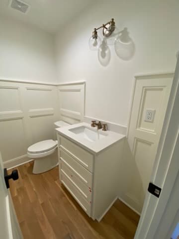 Powder room remodel in Kansas City with white board-and-batten wainscoting and a shaker-style vanity