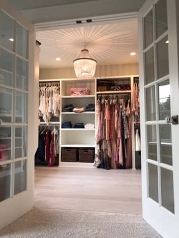 Walk-in closet entry with French doors and custom built-in shelving